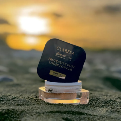 Claresa Protective Dust Loose Powder SPF 30 5g διάφανη λεπτόκοκκη πούδρα σταθεροποίησης μακιγιάζ σε κομψή μπλε συσκευασία, ανοιχτή και τοποθετημένη σε φυσικό outdoor σκηνικό με φωτεινό φόντο.